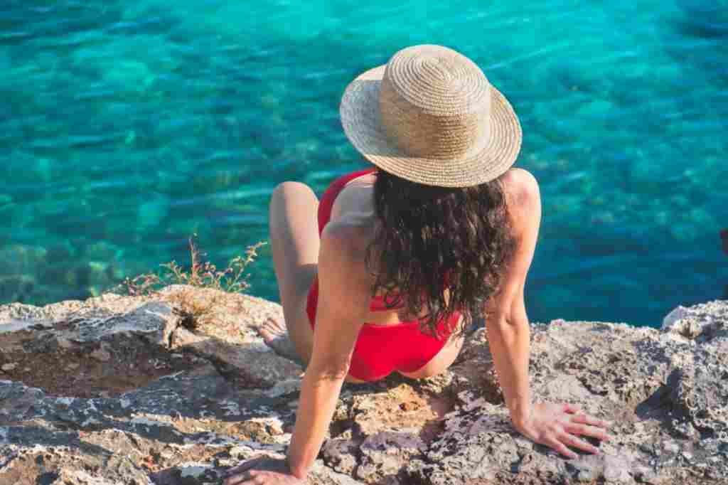 Mädchen im roten Badeanzug am Strand auf Mallorca