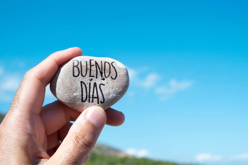 Die Inschrift auf dem Stein „Buenos días“ (Guten Morgen) auf Spanisch auf dem Hintergrund des Meeres