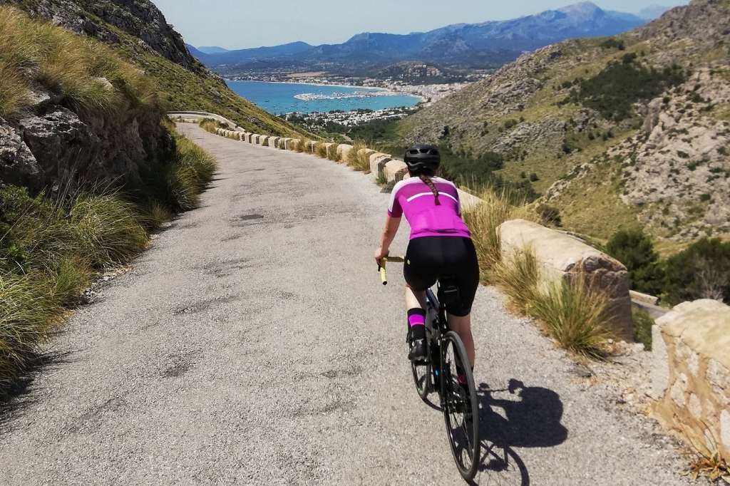 Junge Frau auf dem Fahrrad auf den Straßen von Mallorca